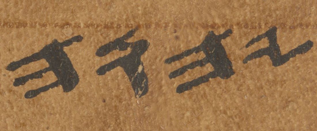 Four Hebrew letters in an older, angular script on brown parchment