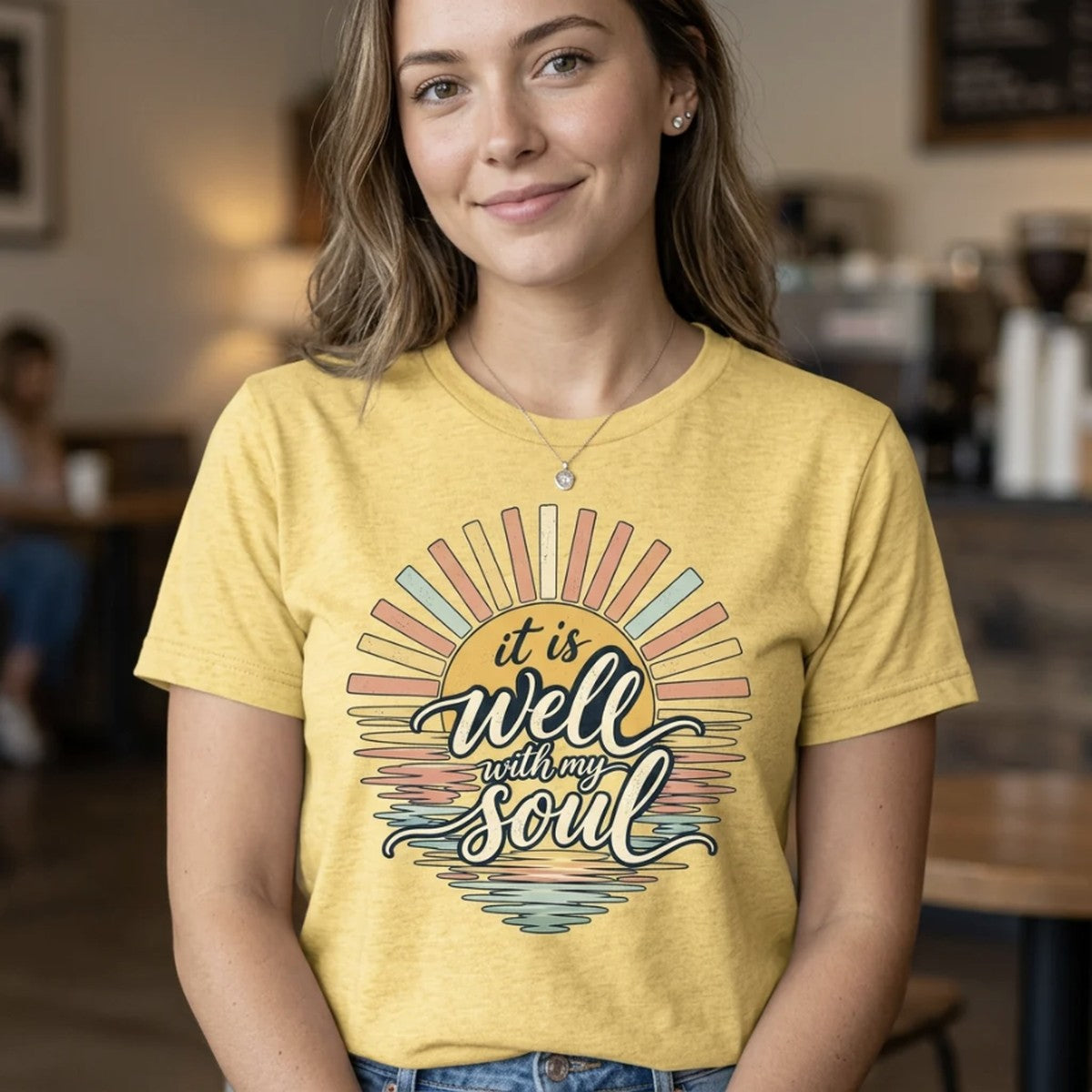 Woman wearing a yellow It Is Well With My Soul Christian t-shirt in a cafe